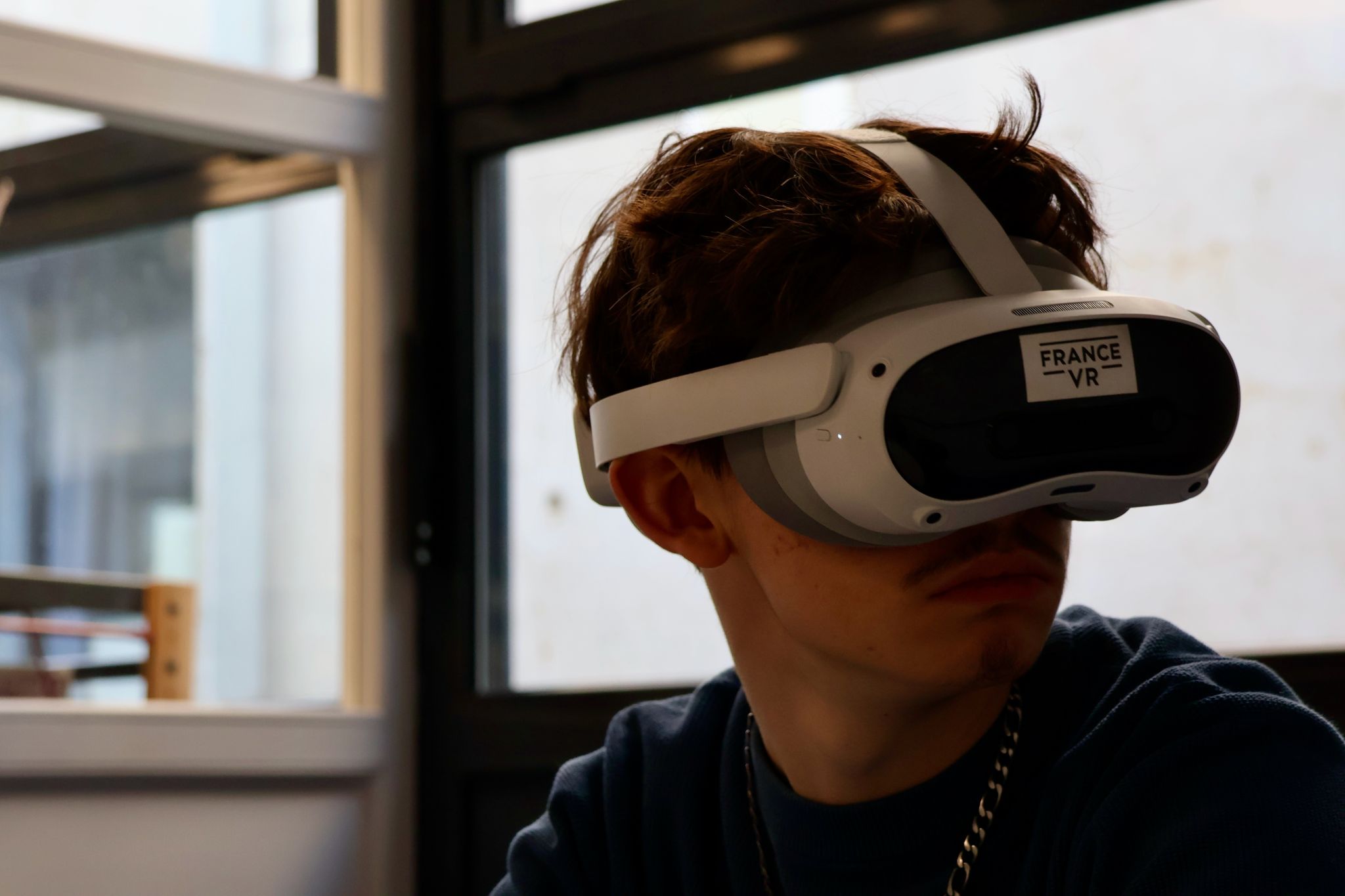 Adolescent complètement immergé dans une expérience VR France VR, tête baissée