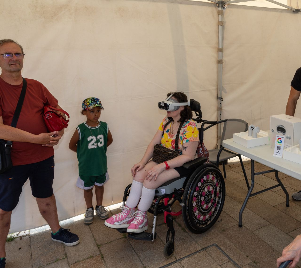 Femme en fauteuil roulant portant un casque VR France VR lors d'un événement, famille autour