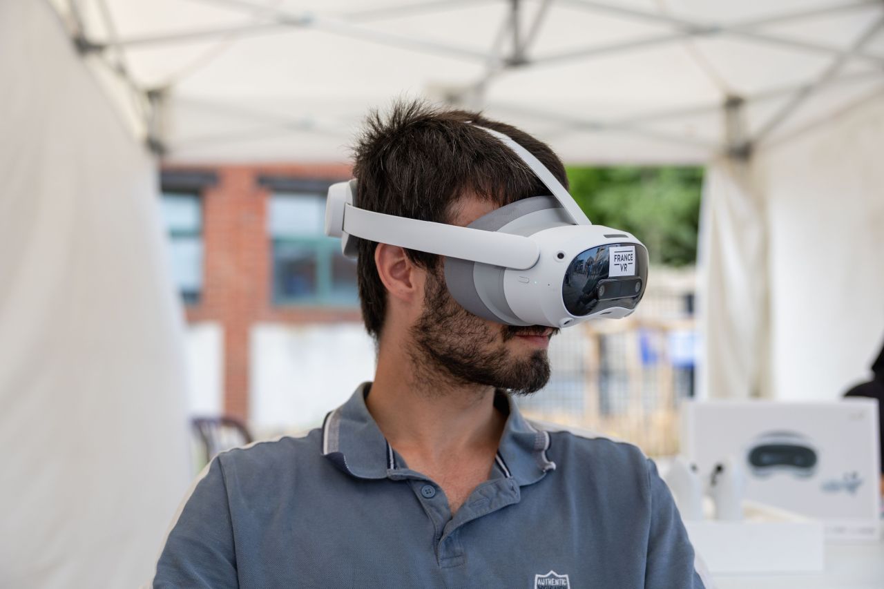 Homme adulte portant un casque VR France VR lors d'une démonstration en plein air sous une tente