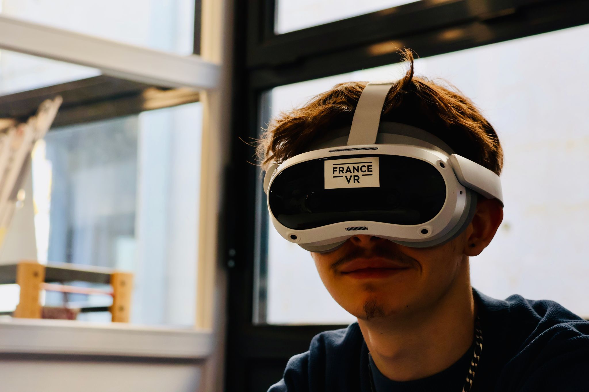 Jeune homme portant un casque VR France VR, regard concentré sur l'expérience